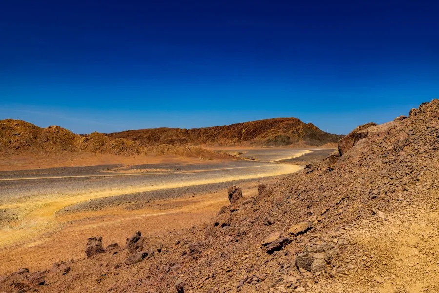 De stilte van de woestijn - Midden in de uitgestrekte woestijn van Marsa Alam ontvouwt zich een landschap dat tegelijk ruig en indrukwekkend is. De kronkelende zandweg leidt je d... - Landscape - Marsa Alam
